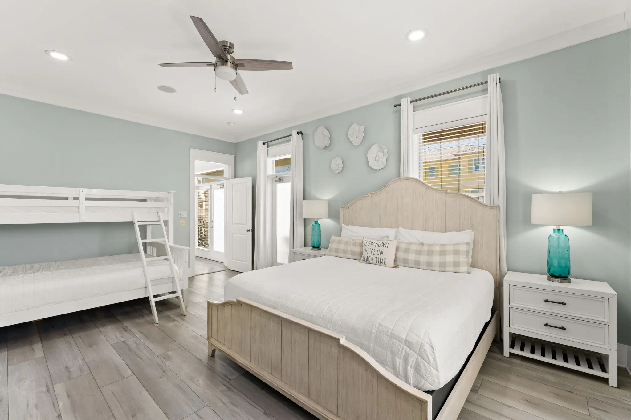 Master bedroom with king bed, built-in bunks, and sage green walls